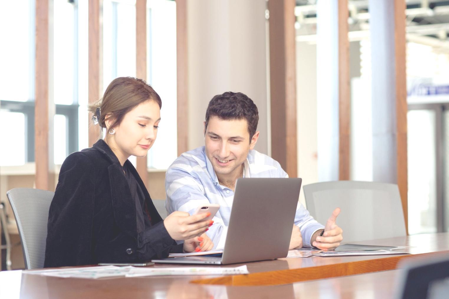 Person plant Finanzen am Laptop mit Unterlagen